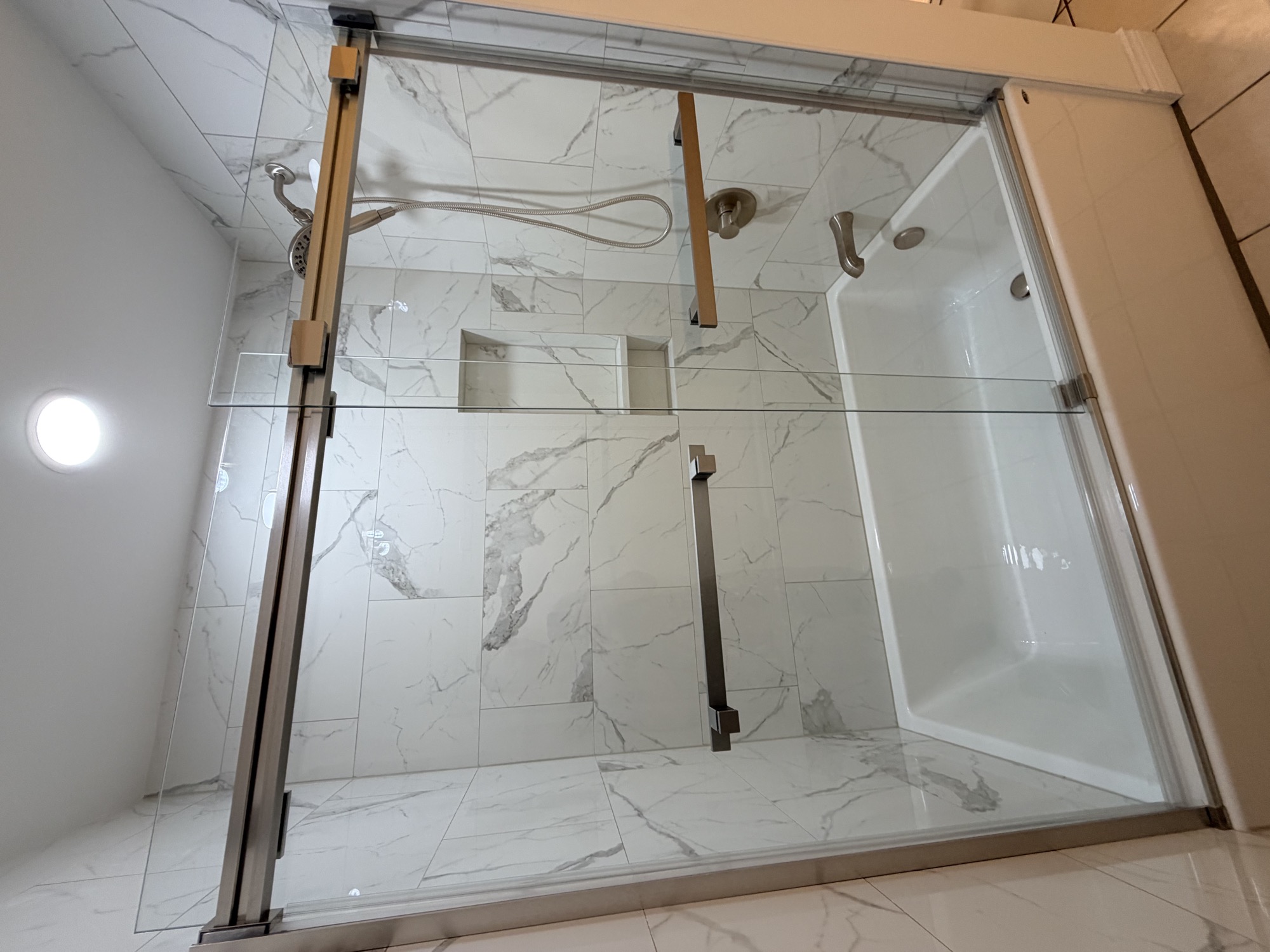 New tub and shower surround with glass doors.
