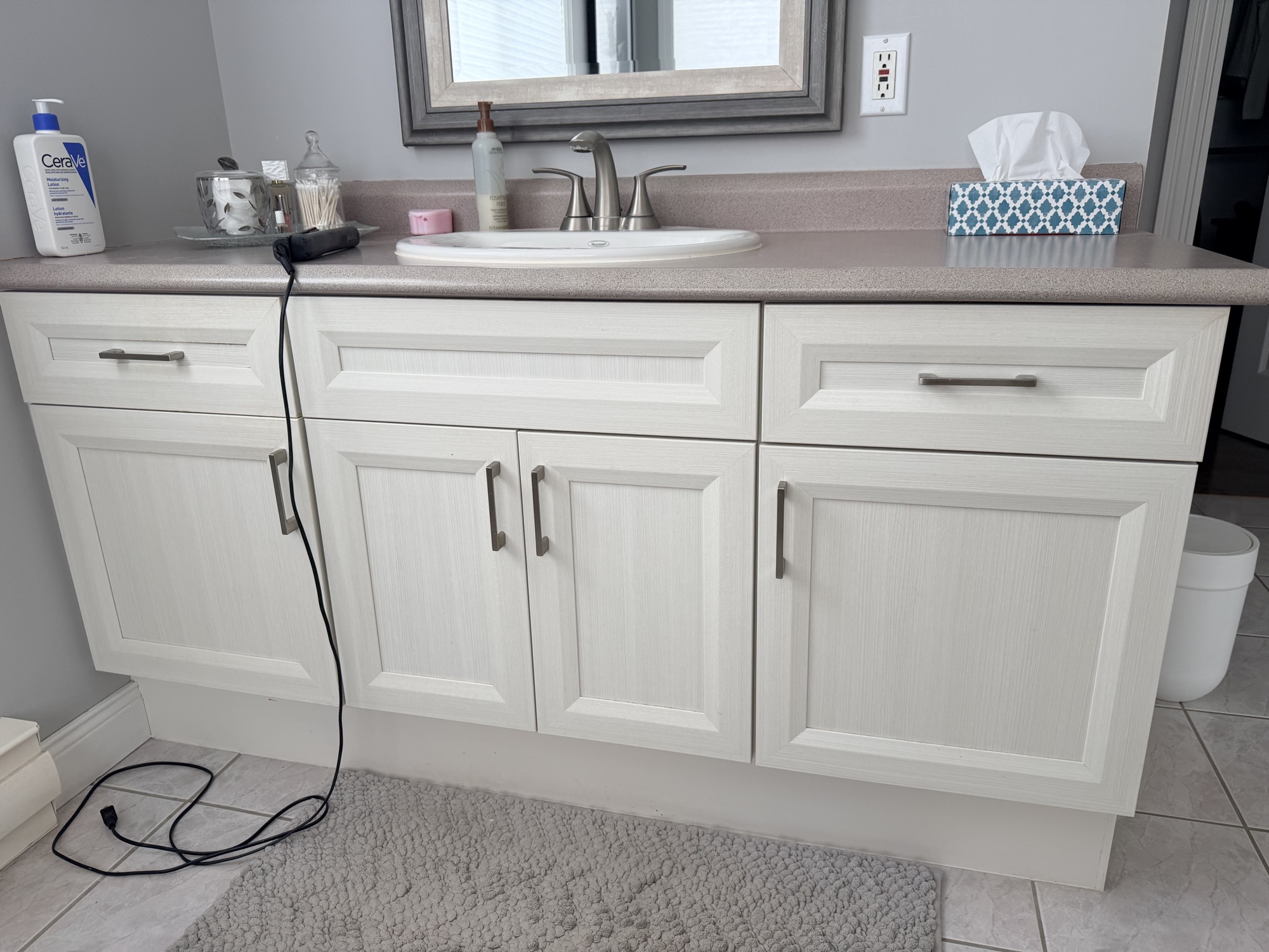 Bathroom vanity refinishing with painted cabinets, new countertop, and sink.