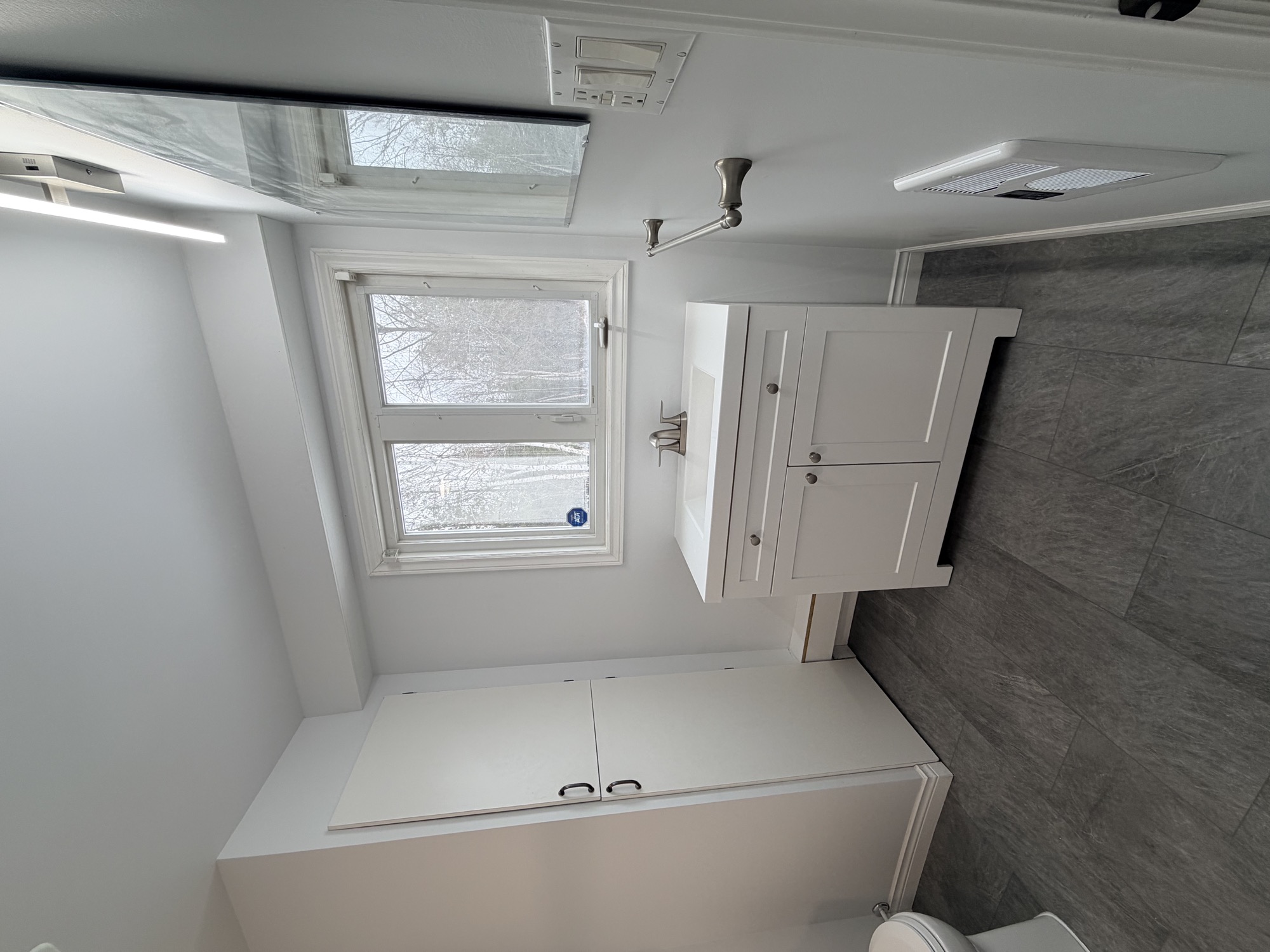 Completed bathroom update with modern flooring, tub and vanity.