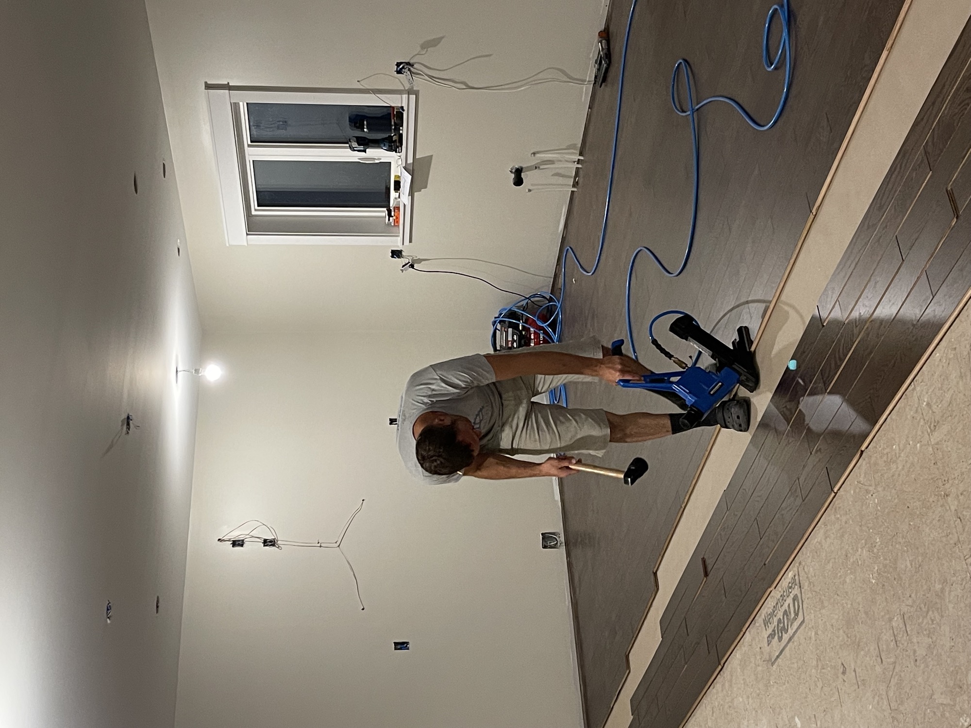 Hardwood flooring installation with rich tones.